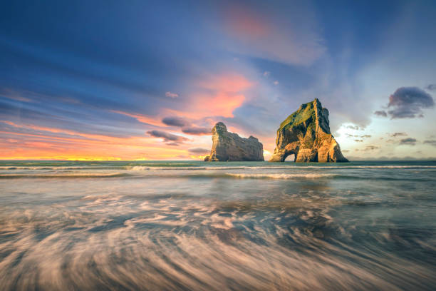spiaggia di wharariki, nuova zelanda allo scenario del tramonto - golden bay foto e immagini stock