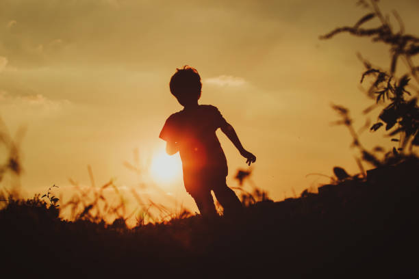istock Silhouette of happy boy running at sunset 639602302