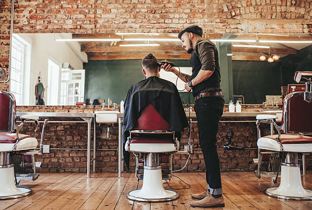 parrucchiere che serve il cliente al barbiere - tagliare i capelli foto e immagini stock