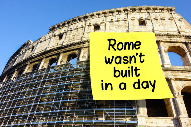 Rome wasn't built in a day idiom Colosseum Rome Rome wasn't built in a day idiom note affixed on Colosseum in Rome, Italy large letter a stock pictures, royalty-free photos & images