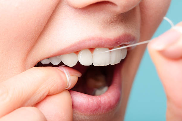 istock side view woman face smiling with dental floss. 639612336