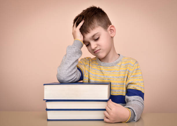 istock Sad young boy and books 639613260