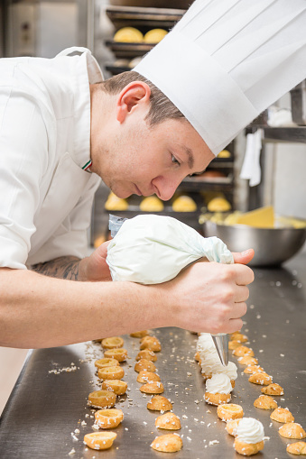 Chef preparing cake with a pastry bag