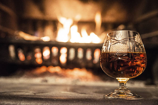 istock Brandy glass on the table near the burning fireplace 639616654