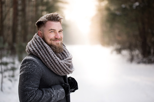 Smiling man on a walk in snowy forest