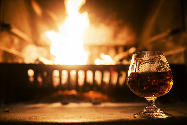 istock Glass alcoholic drink wine in front warm fireplace 639618166