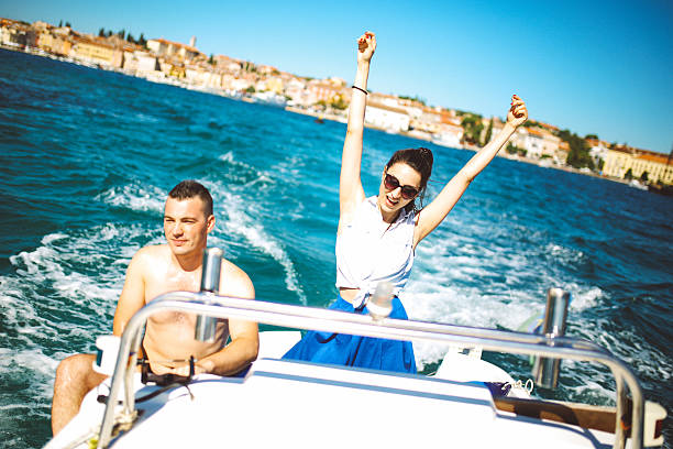 Vintage toned image of young people enjoying the summertime, riding on a small speed boat in the Adriatic sea, near Rovinj, Istria, in Croatia. Happiness, travel, lifestyle concepts.