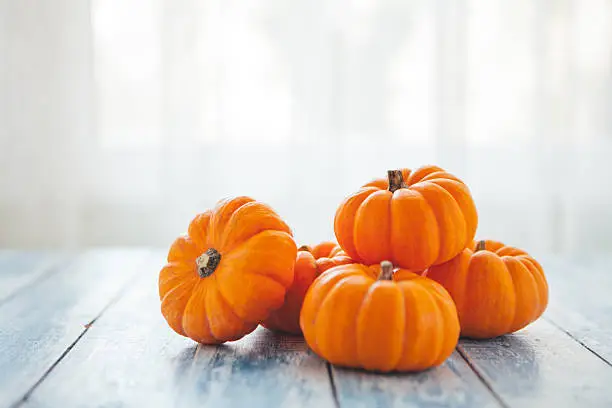 Photo of Mini pumpkins on a rustic wooden table