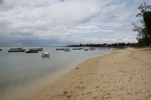 Albion, Mauritius - December 9, 2016: Boats at the the white beach in the western part of Mauritius during a cloudy day.