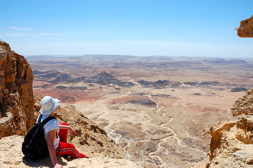 Female hiker viewing volcanic landscape in Negev desert, Israel