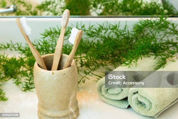 Bambuszahnbürsten In Tasse Handtücher Und Grüns Auf Badezimmerarbeitsplatte Stockfoto und mehr Bilder von Zahnbürste