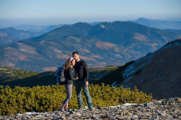 istock Happy couple backpackers enjoying mountains on the background 639631428