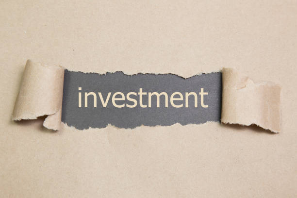 istock investment word written under torn paper. 639632510