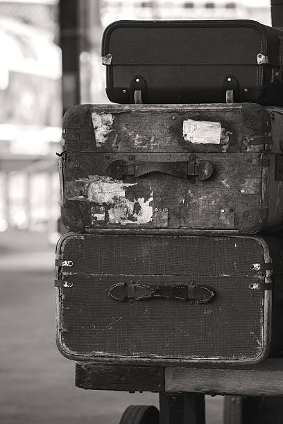 istock Old worn vintage suitcases stacked on train railway platform 639635990