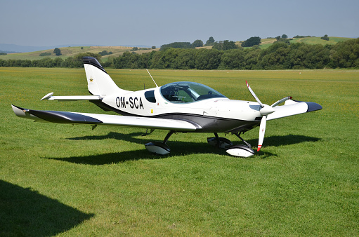 Ocova, Slovakia - August 2, 2014: Ultralight double-seat propeller-driven PS-28 Cruiser airplane stands on grass landing strip in small country airport
