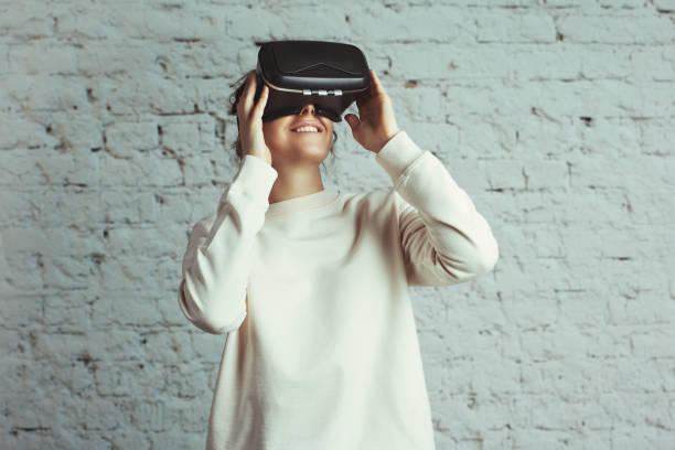 istock Young woman wearing virtual headset 639640206