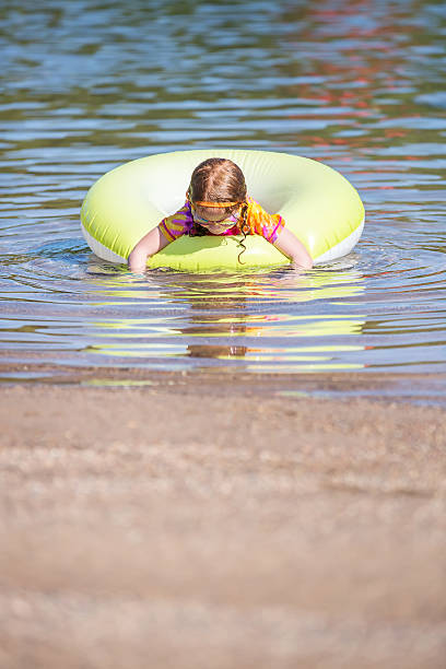 istock Girl Playing In Inner Tube Float at Beach 639644150