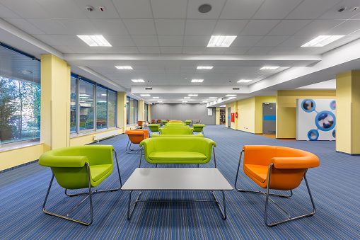 Modern office interior with colorful lounge area, with green and orange furniture