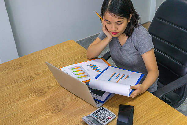 the businesswoman reading report to do research on business income - research report document file imagens e fotografias de stock