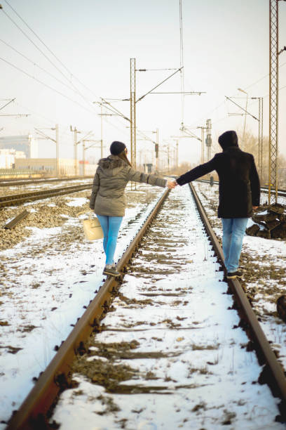 istock Young couple holding hands on a railway 639654080