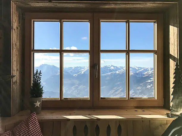 Photo of window with alps in background