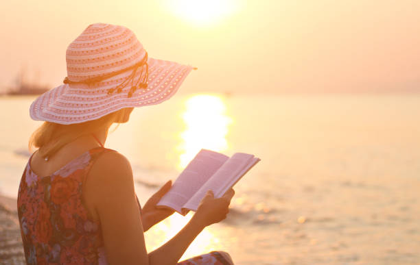 istock Reading a book at sunrise on beach. 639656614