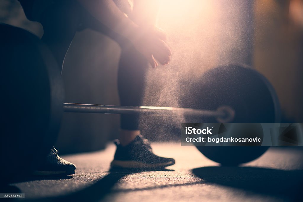 Prepararse para levantar dumbell en un gimnasio - Foto de stock de Entrenamiento combinado libre de derechos