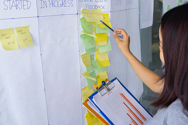 istock Woman cross-checking information in document with sticky notes 639660770