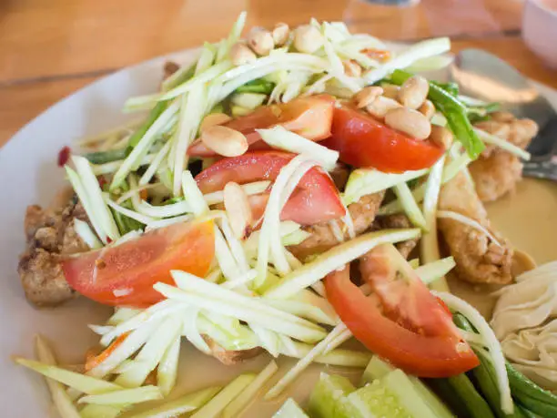 Photo of Papaya Salad (Som Tum Thai) on table, popular Thai food.