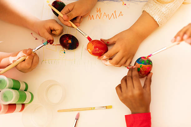 istock Above view of creative children's hands coloring Easter eggs. 639678340