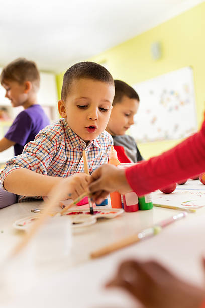 istock Little boy coloring Easter eggs with friends at preschool. 639678508