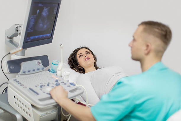 Pregnant woman having ultrasound Woman looking at ultrasound results with doctor gynecological examination photos stock pictures, royalty-free photos & images