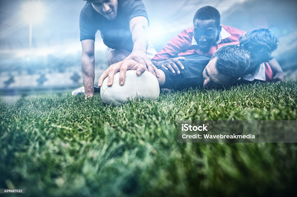 Composite image of rugby fans in arena 3d Rugby fans in arena against rugby players tackling during game 3d Rugby - Sport Stock Photo