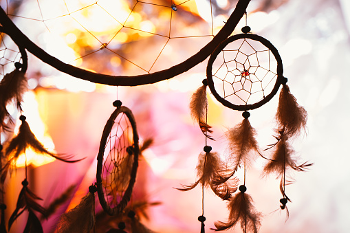 black and white photo of a dream catcher at sunset purple dark background.