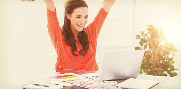 istock Excited woman raising her arms while working on her laptop 639688038