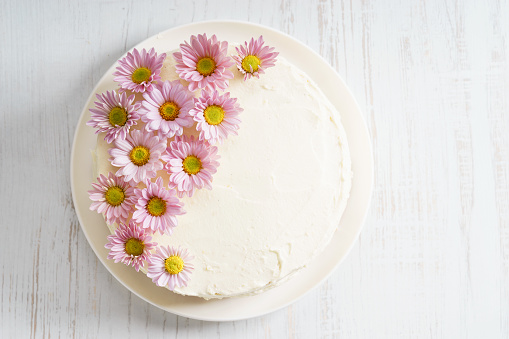 sweet white buttercream round cake with pink flowers on top, valentines love concept