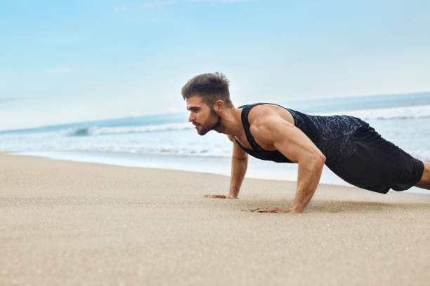 istock Man Exercising, Doing Push Up Exercises On Beach. Fitness Workou 639689414