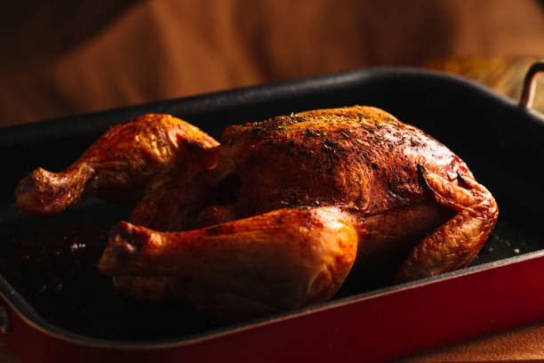 istock Fresh baked chicken with a ruddy crust on dark pan 639690368