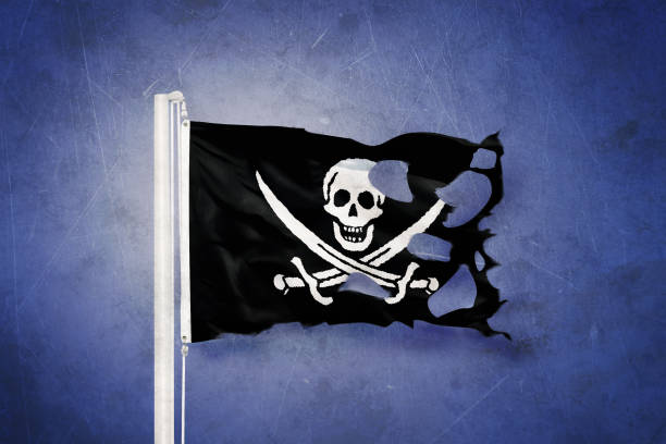 istock Torn Jolly Roger Pirate flag blowing in the wind 639691776