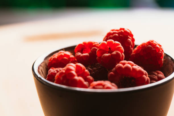 raspberry in a cup on background of wooden boards