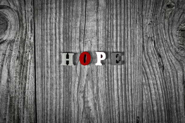 Grey wooden background with the word hope, black and white toning