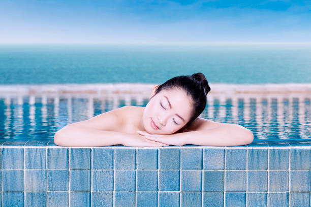istock Model lying over her hands in the pool 639693470