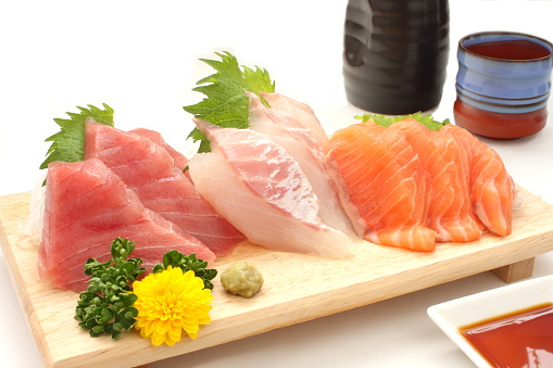 Assorted sake and sashimi (tuna, red sea bream, salmon). I took a picture with a small plate of soy sauce on a white background.