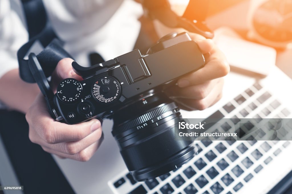 Photographer workplace Photographer holding camera on desk ready to  editing photos on laptop. Studio work, photo service concept. Workplace Photography Stock Photo