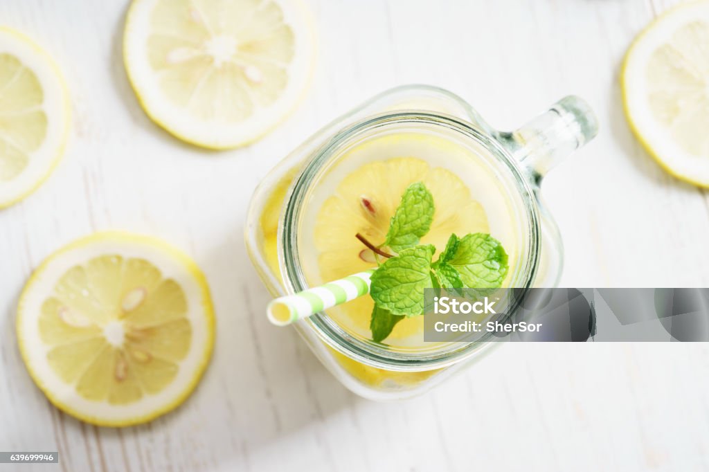 lemonade in jar with green straw lemonade in jar with fresh lemon sliced and sprig of mint, top view Airtight Stock Photo