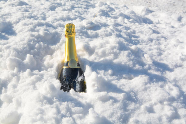 シャンパンのボトルが雪から突き出ている。 - corked ストックフォトと画像