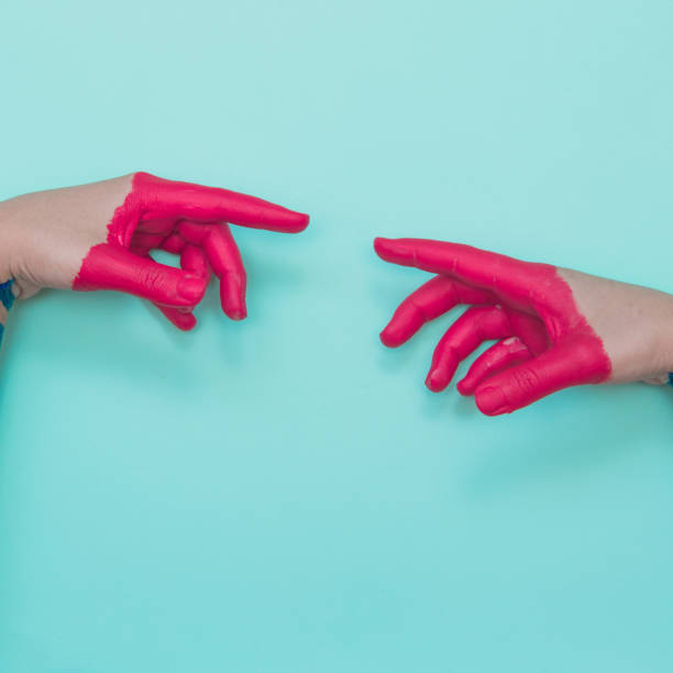 Two painted hands Two painted hands try to reach each other's fingers. Creative connecting conception magenta stock pictures, royalty-free photos & images
