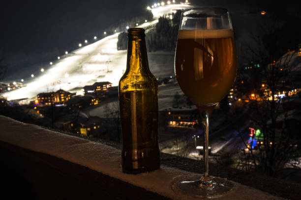 vidrio y botella con cerveza artesanal en un balcón en - beer ski apres ski snow fotografías e imágenes de stock