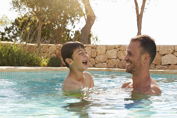 istock Father And Son On Vacation Having Fun In Outdoor Pool 639705908