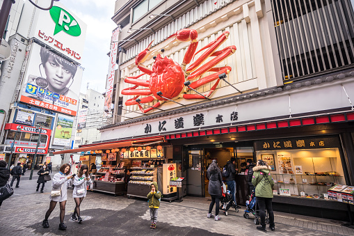 Osaka, Japan - January 20, 2017: Main restaurant of Kani Doraku in Dotonbori, Osaka. Kani Doraku is a Japanese restaurant famous for its delicious crab cuisine. People walking in Dotonbori, a popular area for visitors to the city and boasts a number of well known restaurants. 